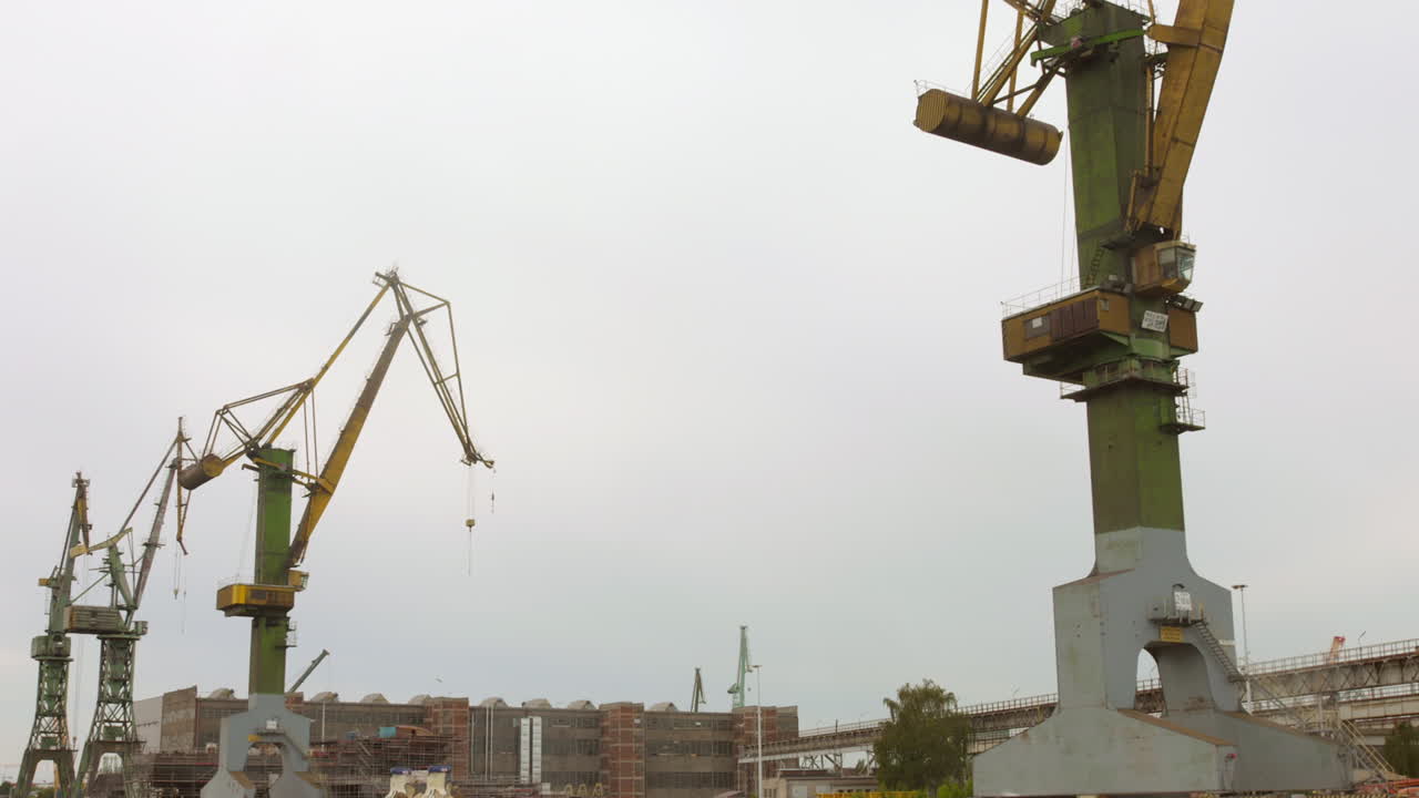Shot of Gdansk Industrial port from boat in Poland on a cloudy day. Cranes on work.