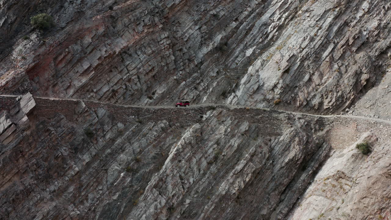 Red Old 4x4 Jeep Driving On Steep Cliffside Towards Fairy Meadows Road In Pakistan