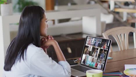 caucasian woman using laptop on video call with colleagues working from home