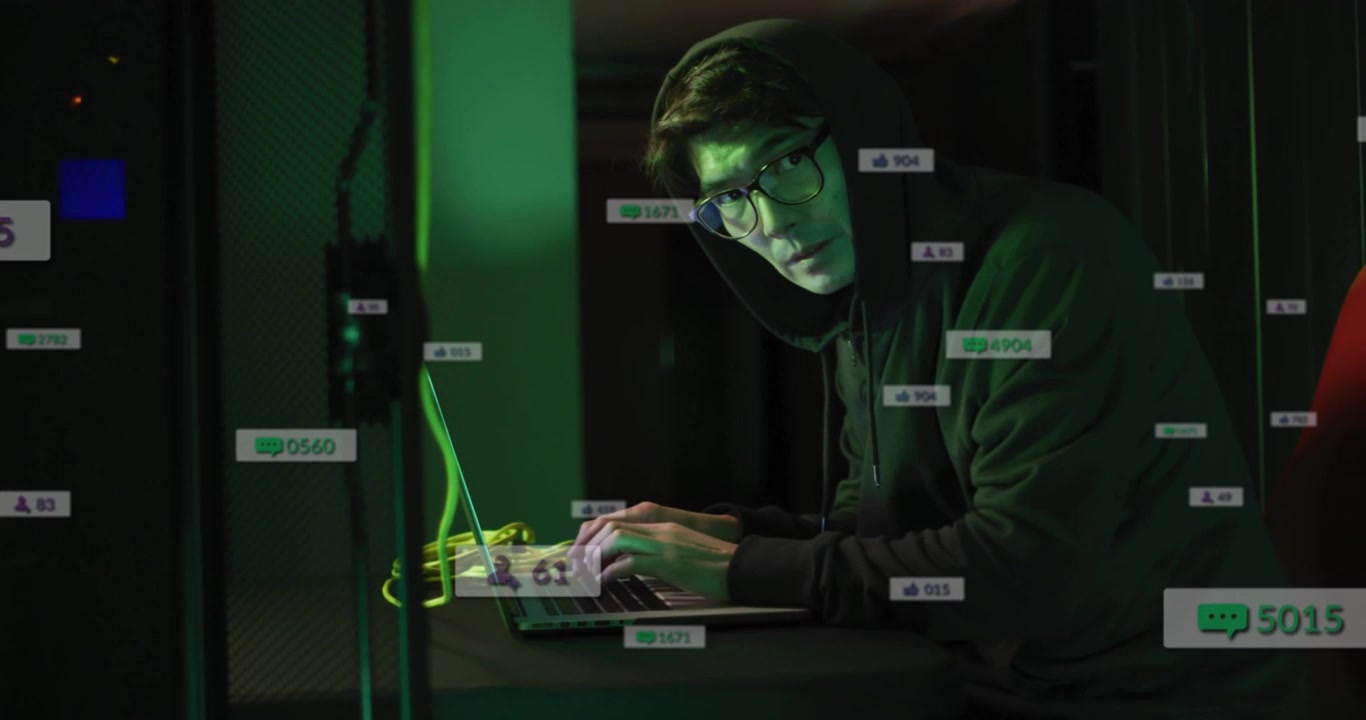 Typing man in hoodie, eyeglasses at server room, with laptop, green cables, server racks, overlays