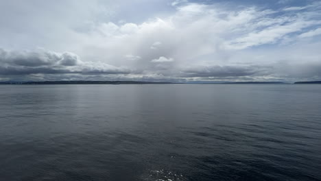 blue sea water moving quickly beneath dramatic cloudy sky, hyperlapse