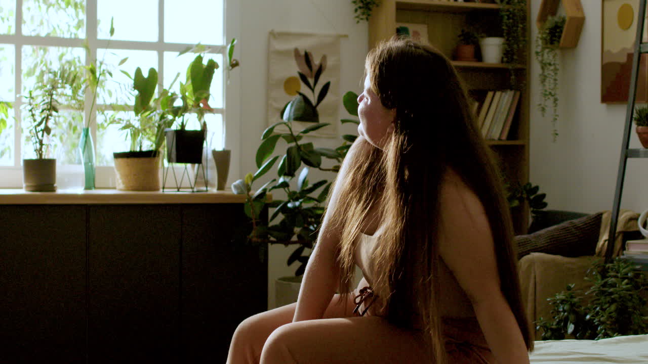 침대에 앉아 있는 젊은 여성