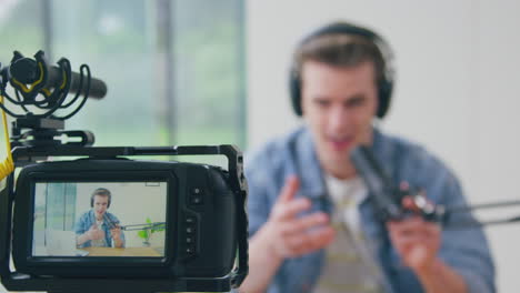 display on back of camera showing male vlogger live streaming to camera