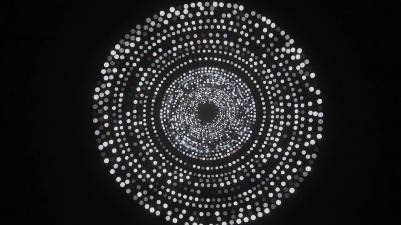 Starting projector activating concentric lights in dark exhibit, with sparkling core for light show