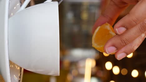 squeezing lemon into tea cup