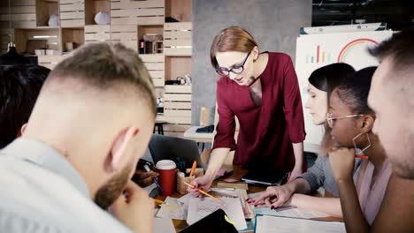 female team leader explains new tasks to employees. happy multiethnic colleagues brainstorming at office meeting 4k