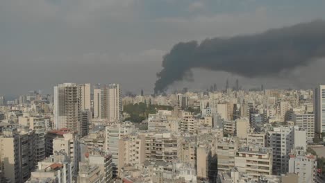 drone footage of heavy black smoke blanketing parts of beirut. the smoke extending over residential and commercial areas. the footage provides a clear view of the smoke's spread across the city
