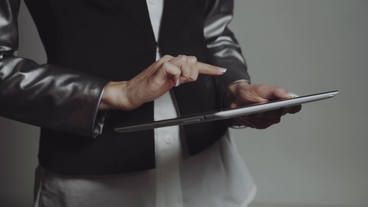Business woman with tablet. Young pretty business woman taping on tablet in studio