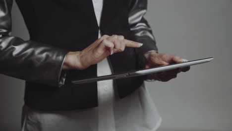 business woman with tablet. young pretty business woman taping on tablet in studio