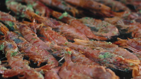 closeup chef hands laying out shrimps on grill. man hands grilling crawfish.