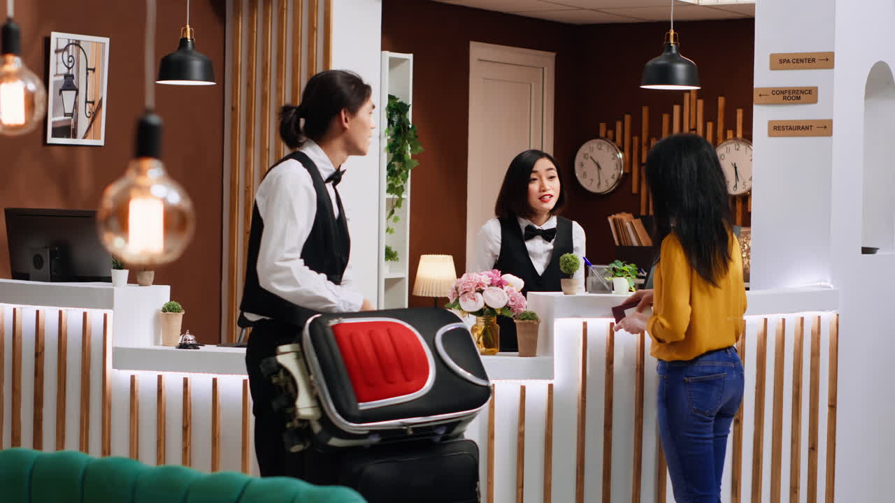 Cliente asiatico che finisce con il processo di check-in alla reception