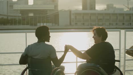 hombre y mujer jóvenes felices usando sillas de ruedas saliendo en el muelle