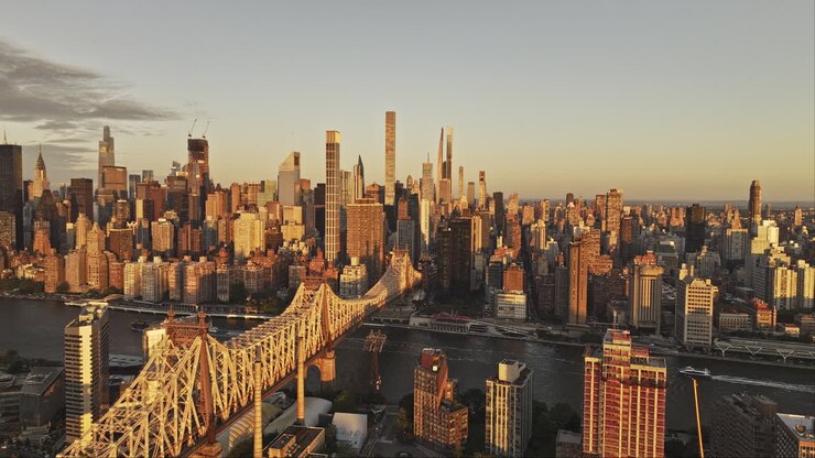 NYC New York Aerial v370 drone flyover Roosevelt Island capturing Queensboro Bridge over East river, Lenox Hill and Midtown Manhattan cityscape at sunrise - Shot with Mavic 3 Pro Cine - September 2023