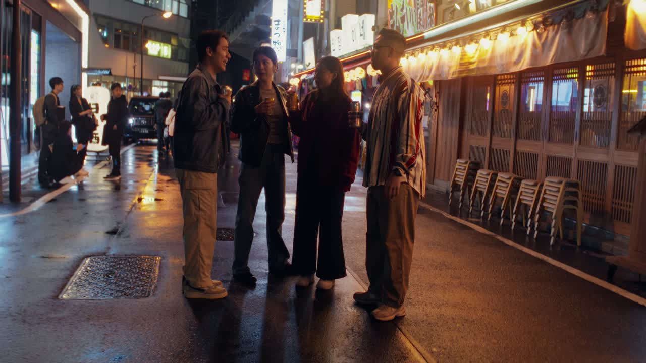Friends Enjoying Drinks at Night in a City Street