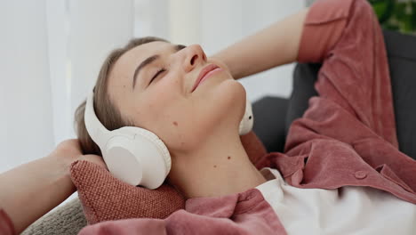 woman relaxing on couch with headphones