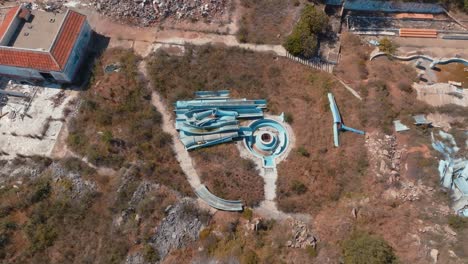 pedazos de tobogán de agua rotos en un parque abandonado, vista aérea de pájaro giratorio