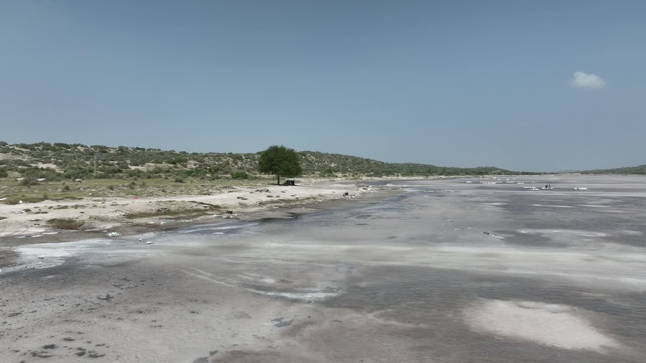 un árbol solitario, revelado a través de imágenes aéreas de drones, se encuentra en medio del paisaje panorámico del lago salado en sanghar sindh, pakistán