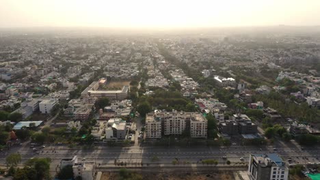 the beautiful city of indore with vehicles travelling on the road on a sunrise in india. - aerial drone shot