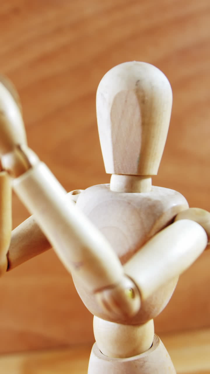 estatuilla de pie con los brazos cruzados en un piso de madera