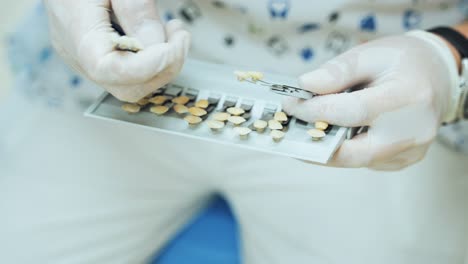 the dentist selects the right shade of the tooth on a vitascale. palette for tooth color. training of dentists on a model of teeth