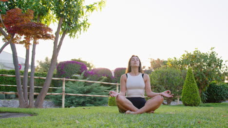 wide shot of a young woman doing yoga and mindfulness in a garden