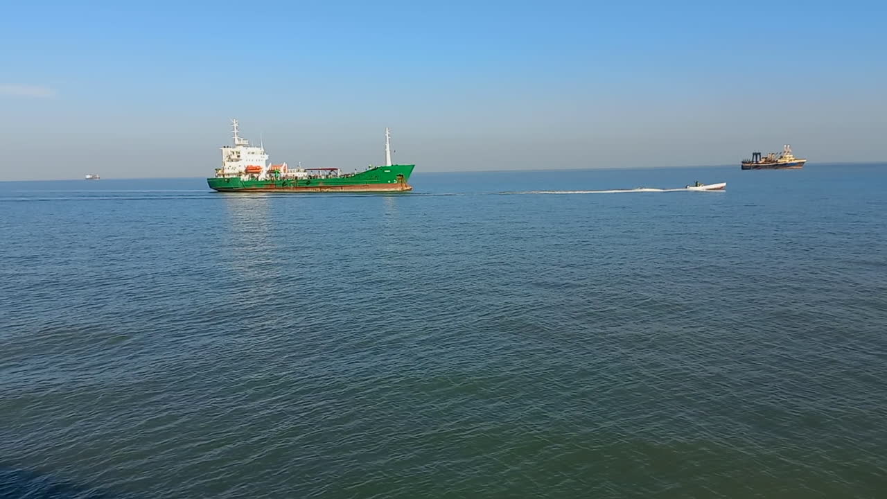 Fishing boats along the coast of Guinea Bissau in the Atlantic ocean. A small boat passes at great speed
