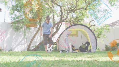 Animation-of-school-items-icons-over-happy-caucasian-boy-playing-football