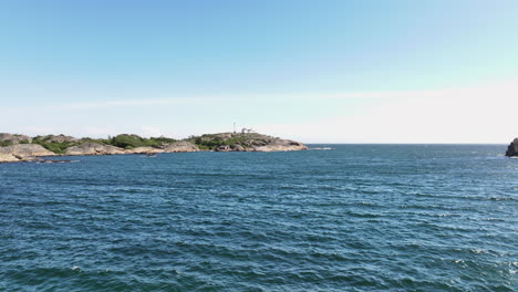 distant view of stavernsodden lighthouse across the sea in larvik, vestfold og telemark, norway