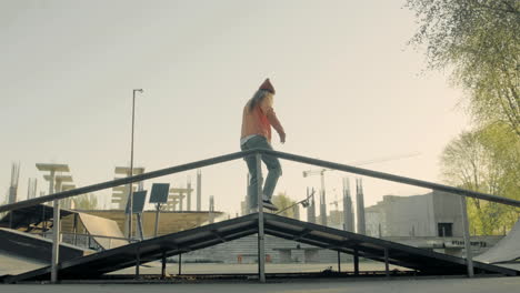 Junges-Skatermädchen,-Das-Bei-Sonnenuntergang-In-Einem-Skatepark-Eine-Rampe-Hinunterrutscht