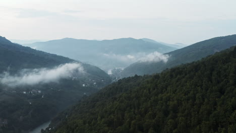 녹색 산과 발칸 산맥의 낮은 구름 위를 천천히 날아