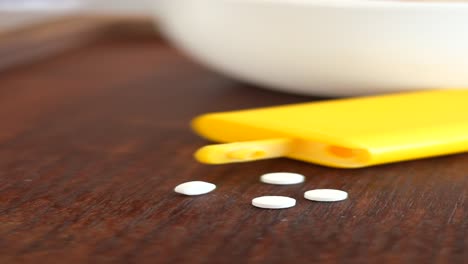 sweetener tablets on wooden table with coffee cup