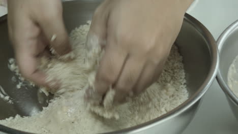 close-up of chicken being dipped on sauce and special mix