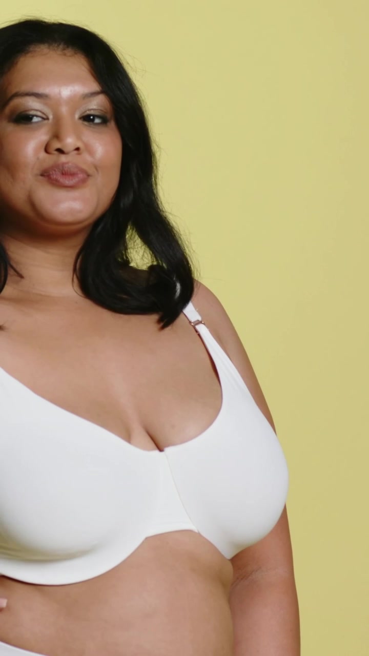 Video verticale: Modella in posa su indicazione, che si gira e si muove in studio, in reggiseno e slip bianchi, con spazio per il testo.