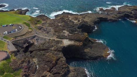 kiama blowhole in a rocky peninsula with blue sea at daytime in nsw, australia