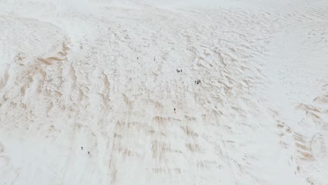 Vista-De-Pájaro-De-La-Gente-Jugando-En-El-Lago-Nacional-Dunas-De-Osos-Durmientes-En-Invierno