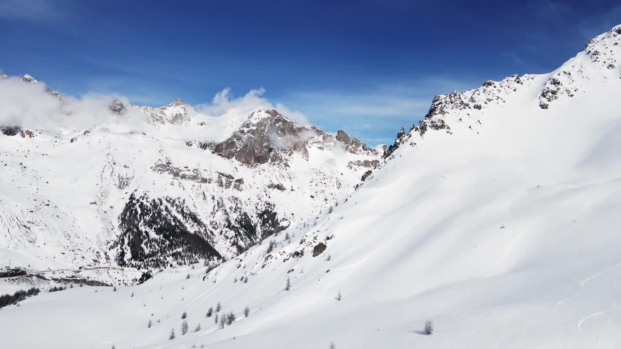 A breathtaking aerial view of snow-covered mountain peaks, showcasing serene alpine landscapes and crisp natural beauty during winter