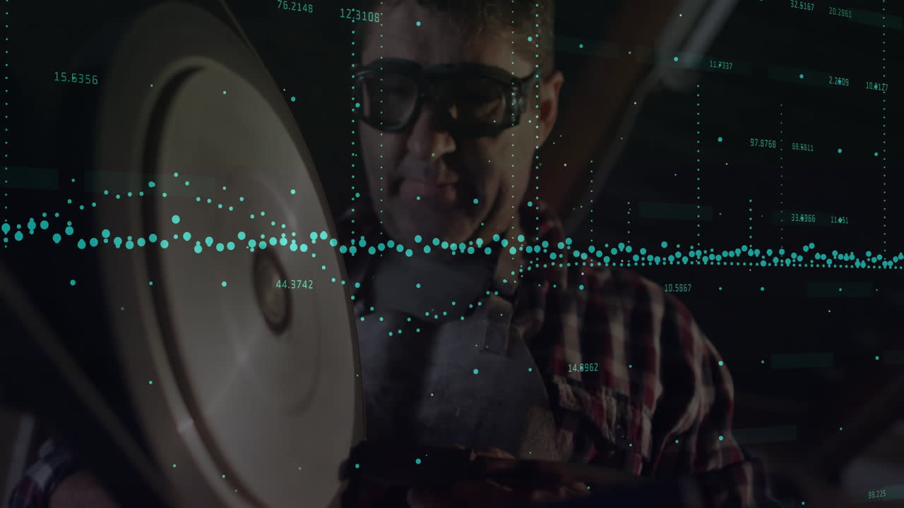 Mature male machinist operating grinder in tech workshop, producing sparks with teal data overlay