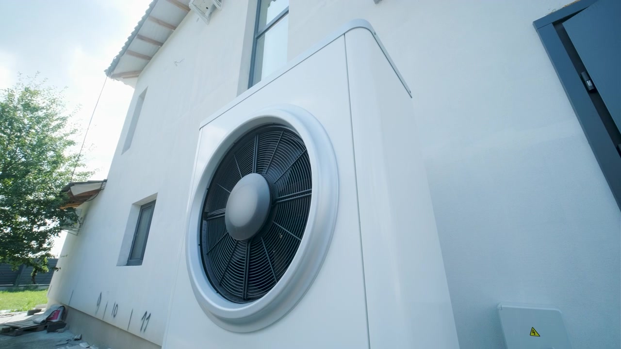 Moderne lucht-water warmtepompunit buiten een woonhuis geïnstalleerd