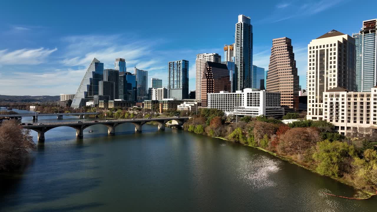 Vista aérea baixa sobre o rio, em direção a arranha-céus, em um dia ensolarado de outono em Austin, EUA.