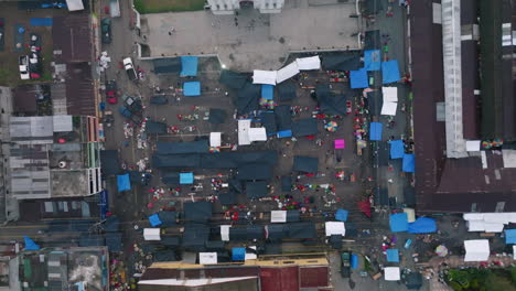 Top-down-sped-up-aerial-footage-of-vendors-and-shoppers-moving-around-the-market-in-San-Juan-Ostuncalco,-Guatemala