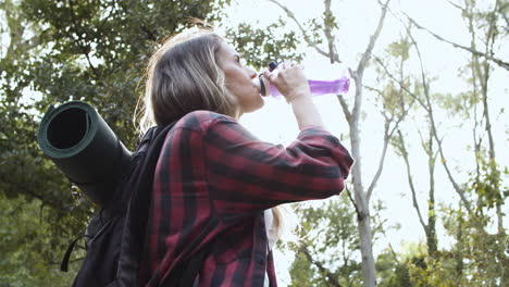 trekking girl drinking fresh water on her way to the camping