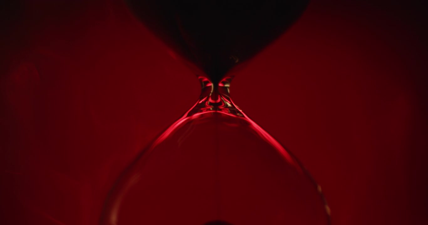 Sand clock on scarlet background