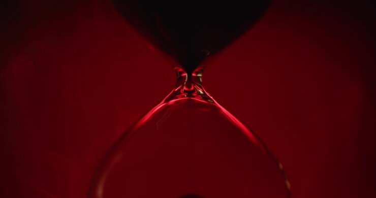 Sand clock on scarlet background