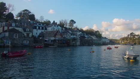 tranquil evening view of fowey riverside homes of port town, cornwall, england, united kingdom - handheld wide shot