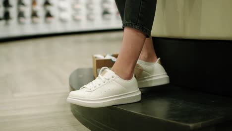 Woman-Is-Trying-New-White-Sneakers-In-Shoe-Store