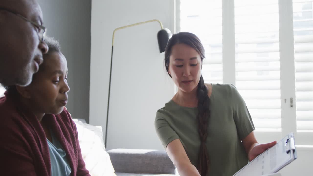 미소 짓는 아시아 여성 상담사 는 아프리카계 미국인 노인 부부 에게 조언 을 하고 있다