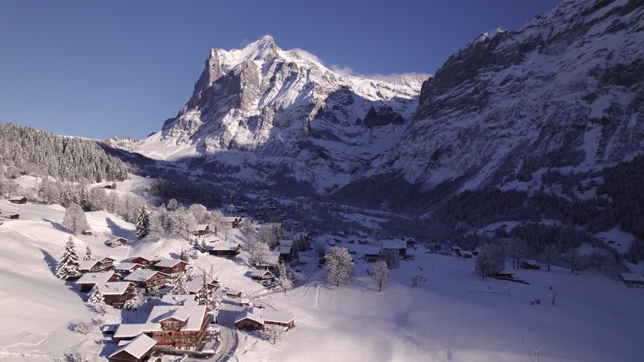 empujando sobre chalets cubiertos de nieve en terrassenweg hacia el lado este de grindelwald con fabulosas vistas del monte wetterhorn