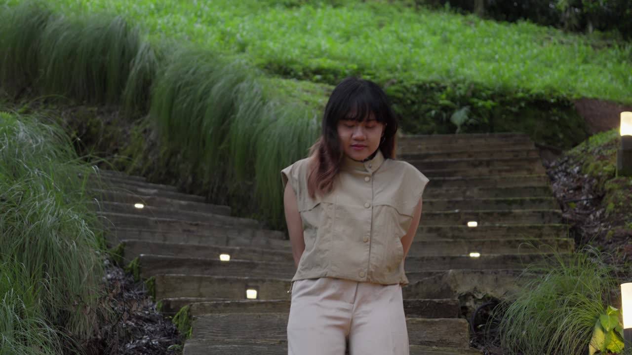 Indonesian girl walking on a tea plantation, enjoying the scenic natural environment