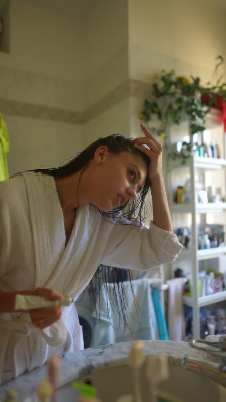 Donna che applica una crema in bagno