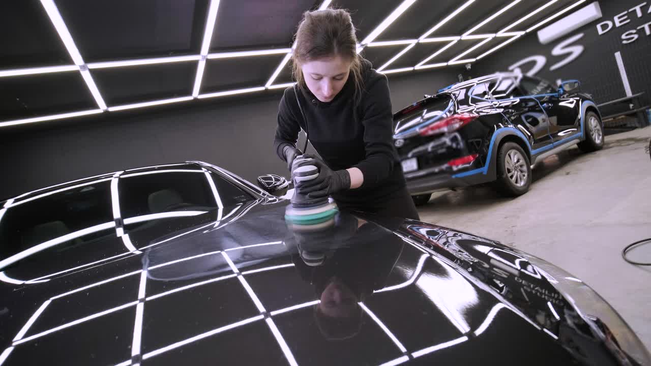 trabajador pulir un coche negro. detalles del coche - mujer están usando maquinaria pulidores de automóviles mantenimiento para eliminar marcas reparación de acuerdo con la superficie de la pintura del coche antes de contin
